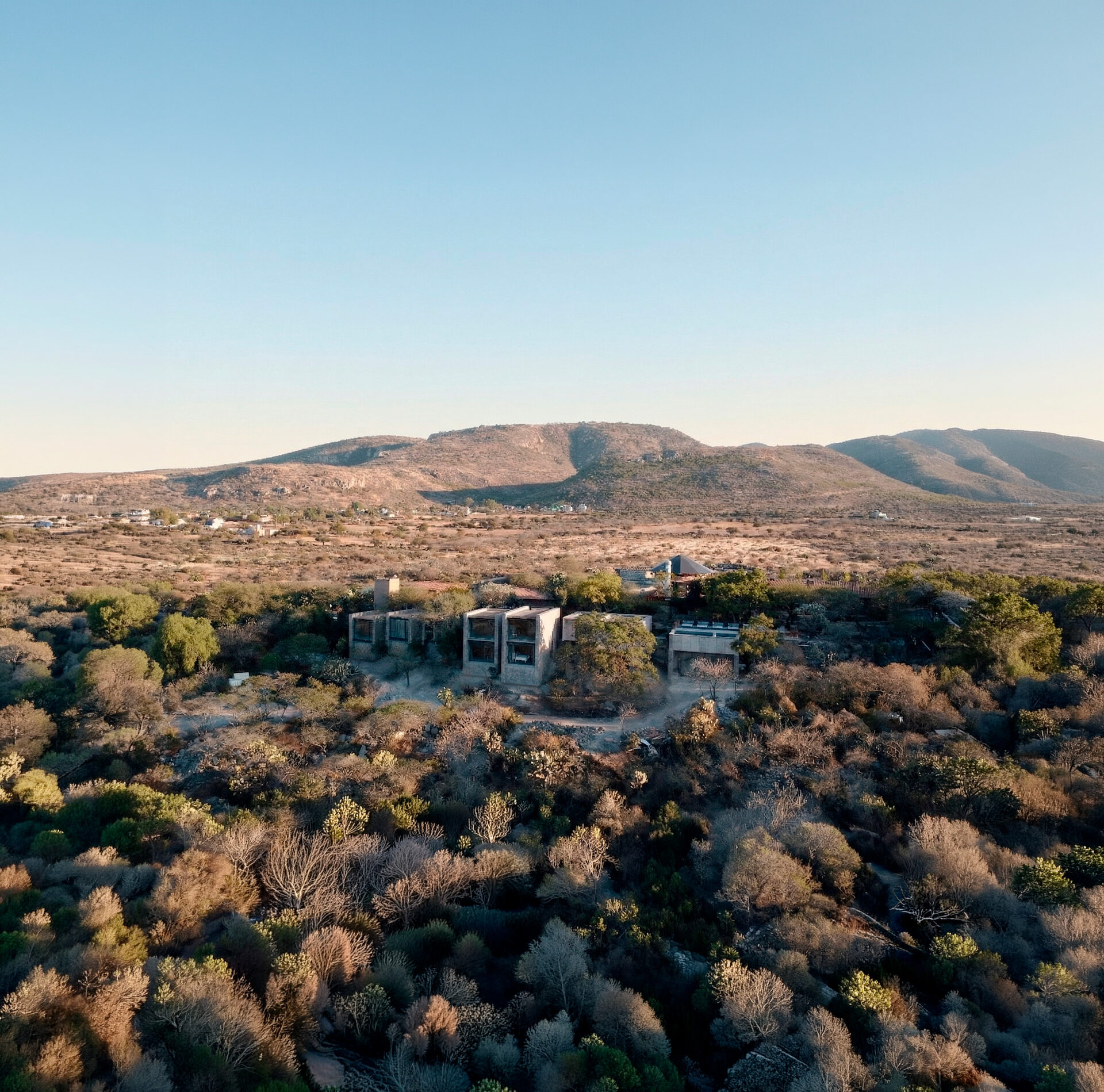 Shala ceremonial al atardecer con lago y escultura en Reserva X
