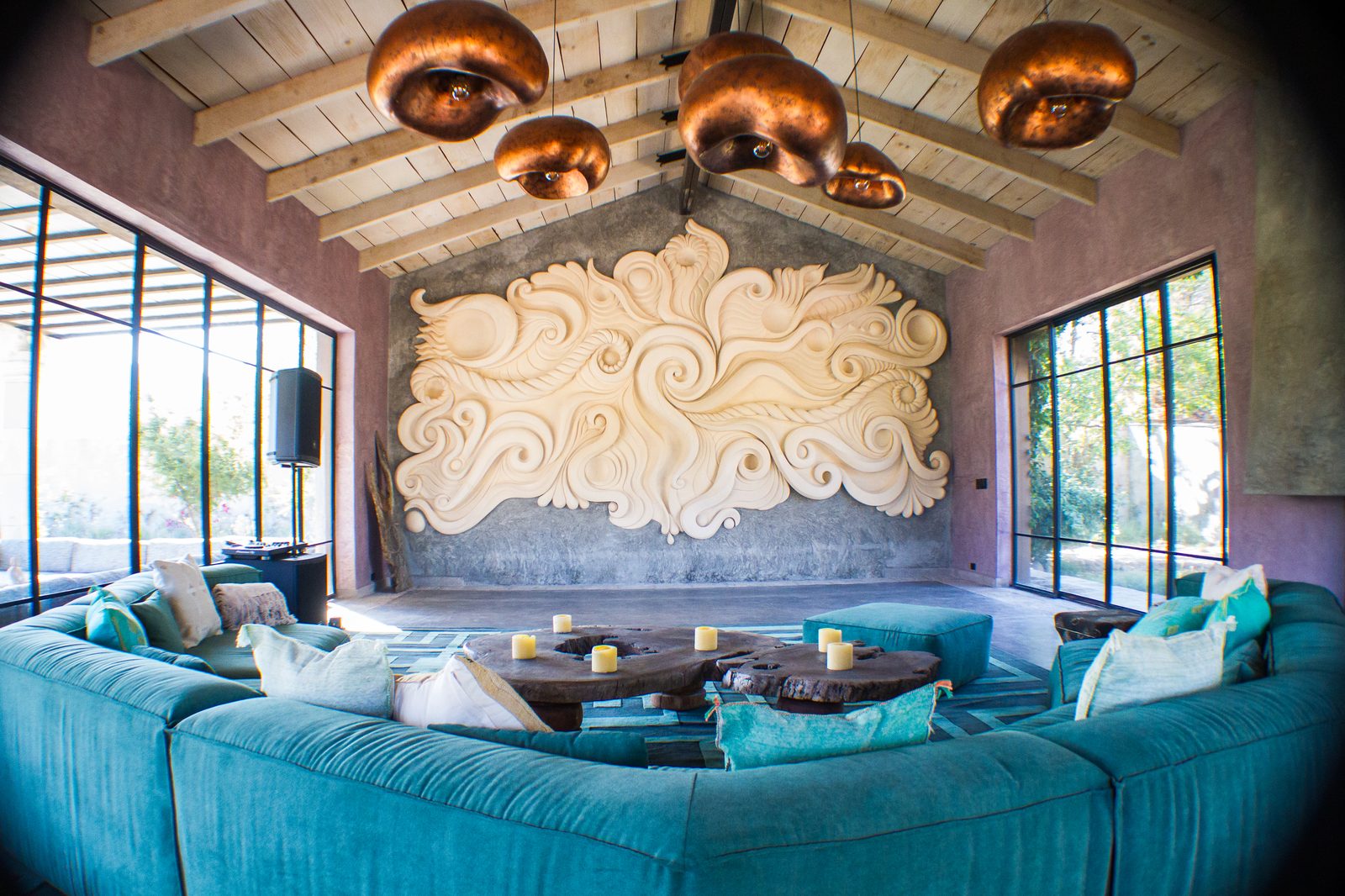 Sala con sofá turquesa y lámparas de cobre